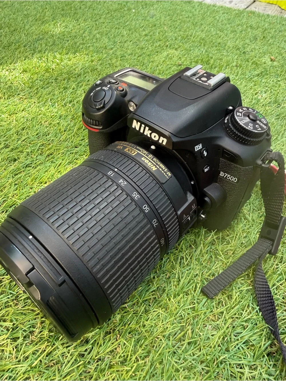 Nikon D7500 DSLR Camera with Black Lens and Red Strap